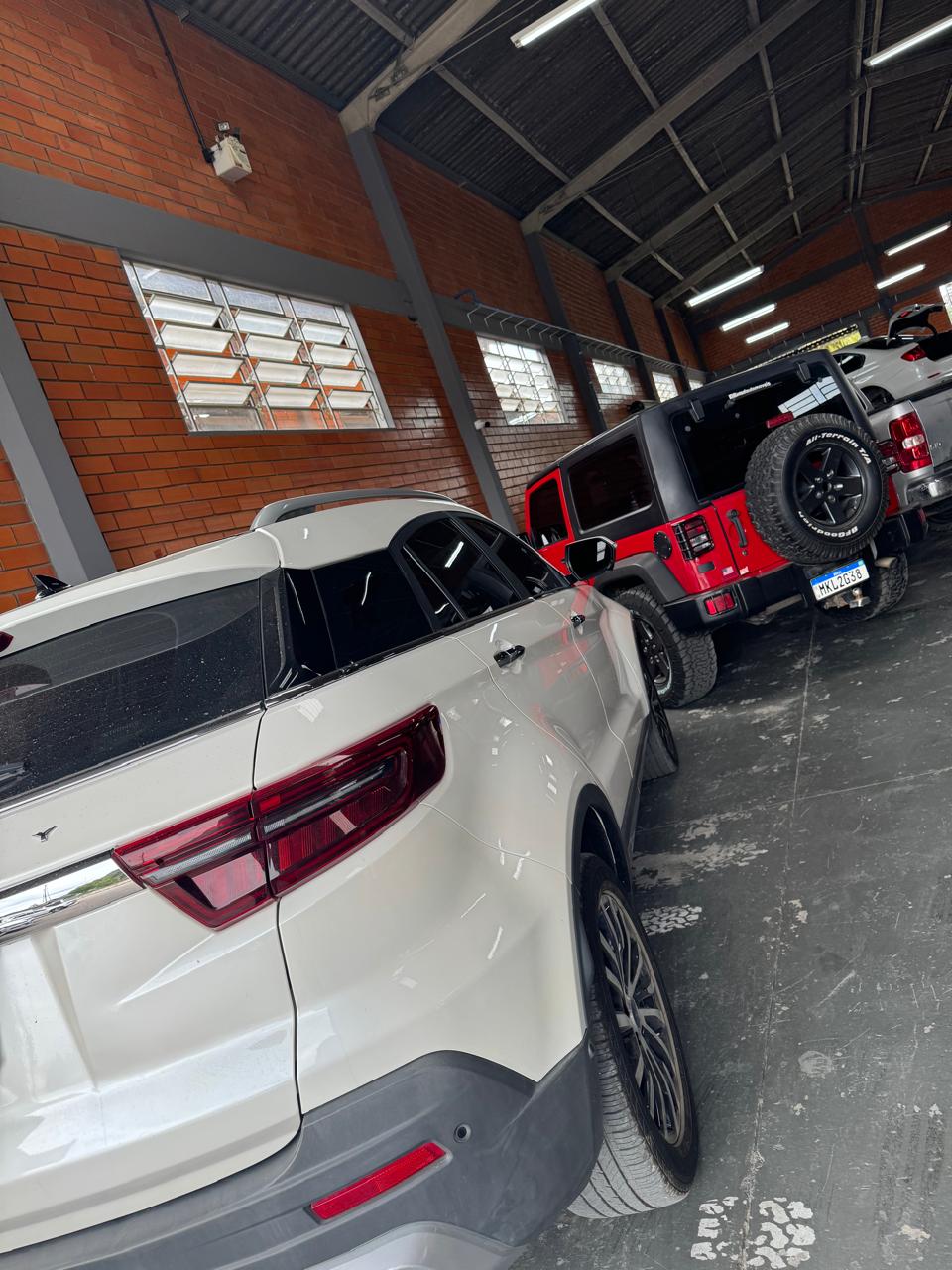 SUV e Jeep vermelho dentro da oficina Testoni