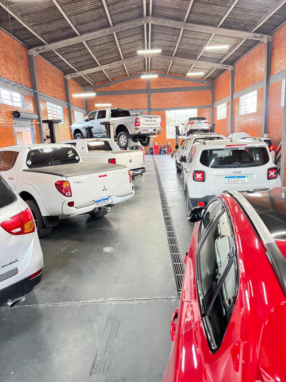 Oficina com caminhonetes RAM, veículos nacionais e elevadores