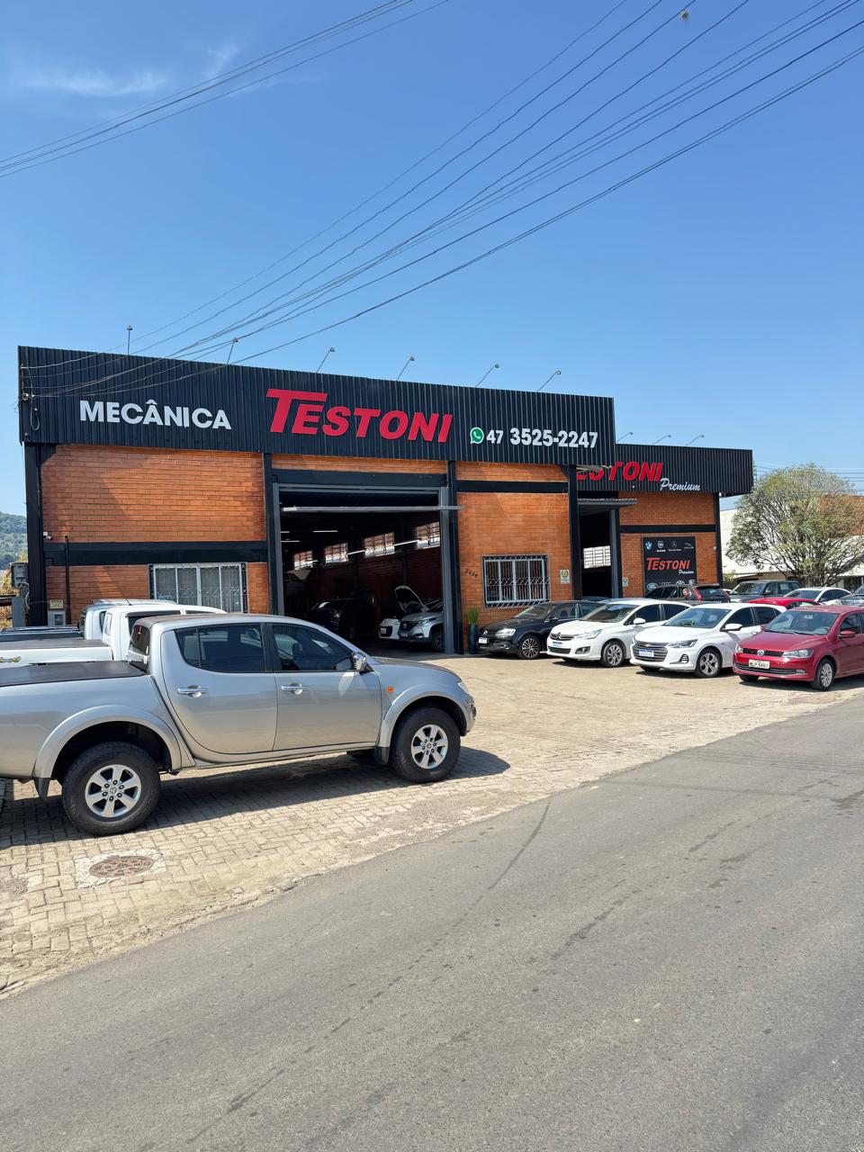 Fachada de tijolos da Testoni com veículos no estacionamento